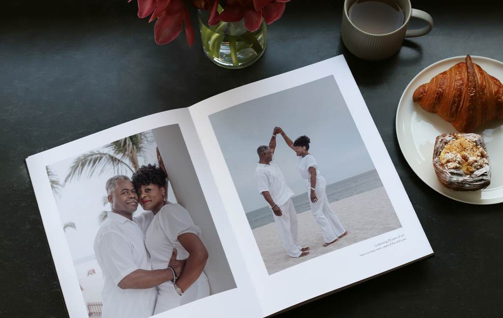 Photo book filled with 25 years of marriage memories on a silver tray.