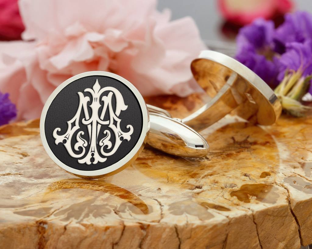 Sterling silver cufflinks engraved with initials on a velvet background